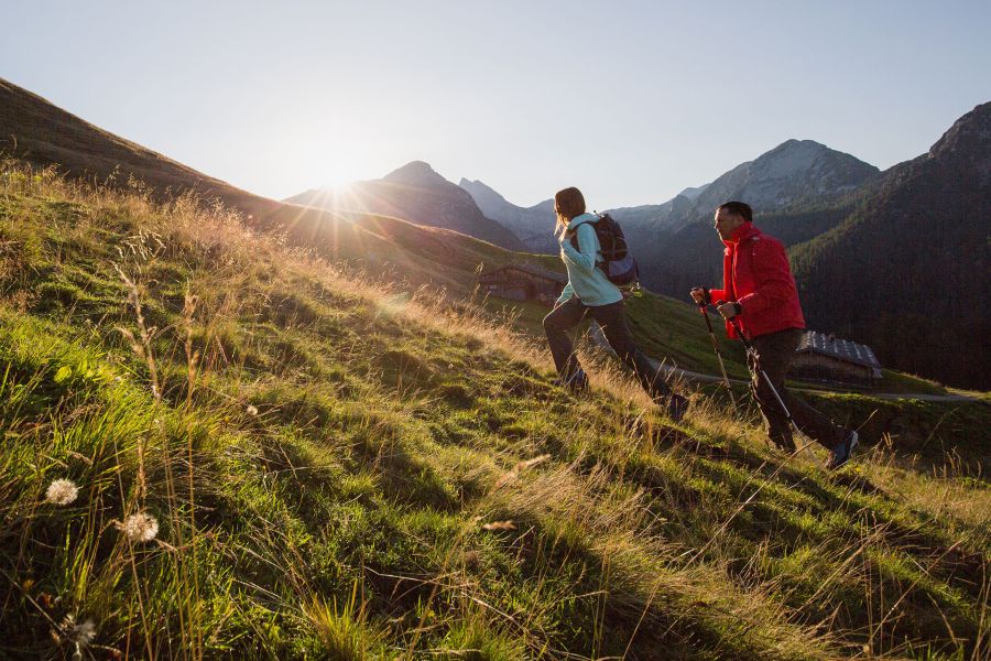 Wanderer gehen den Berg bei Sonnenaufgang hinauf