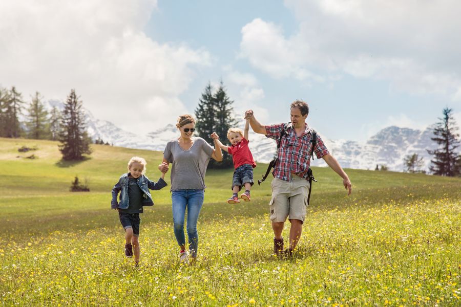 Familie spaziert auf den Blumenwiesen in Unken