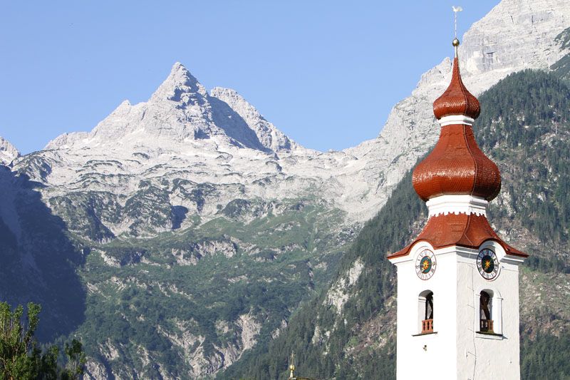 Der Kirchturm von Lofer mit dem Steinernen Meer im Hintergrund