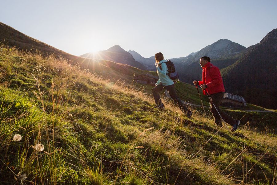 Wanderer gehen den Berg bei Sonnenaufgang hinauf