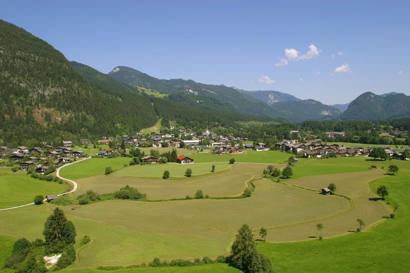 Luftaufnahme von Lofer mit Wiesen Haeusern und den Bergen im Hintergrund